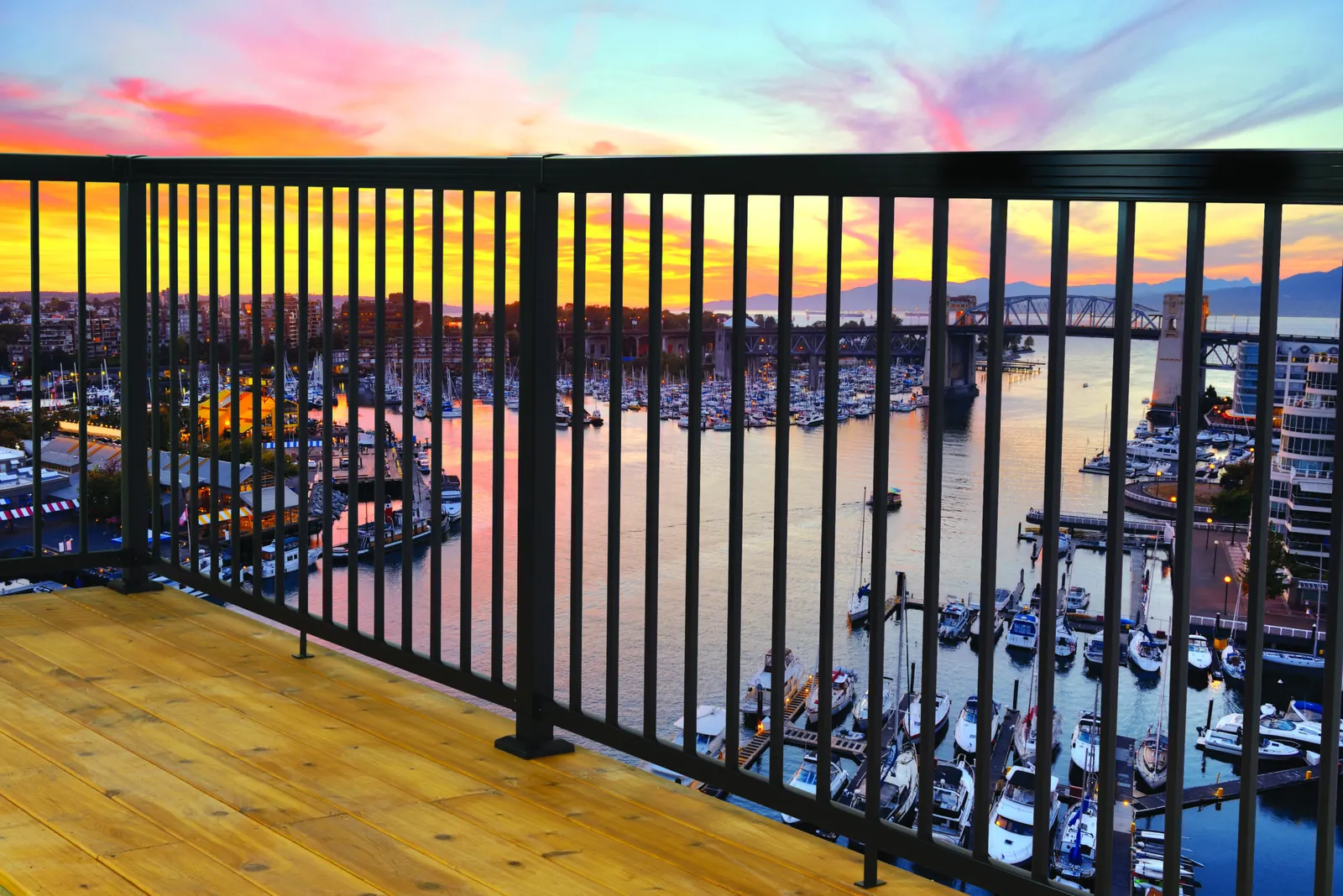 Black aluminum railing over a marina at sunset