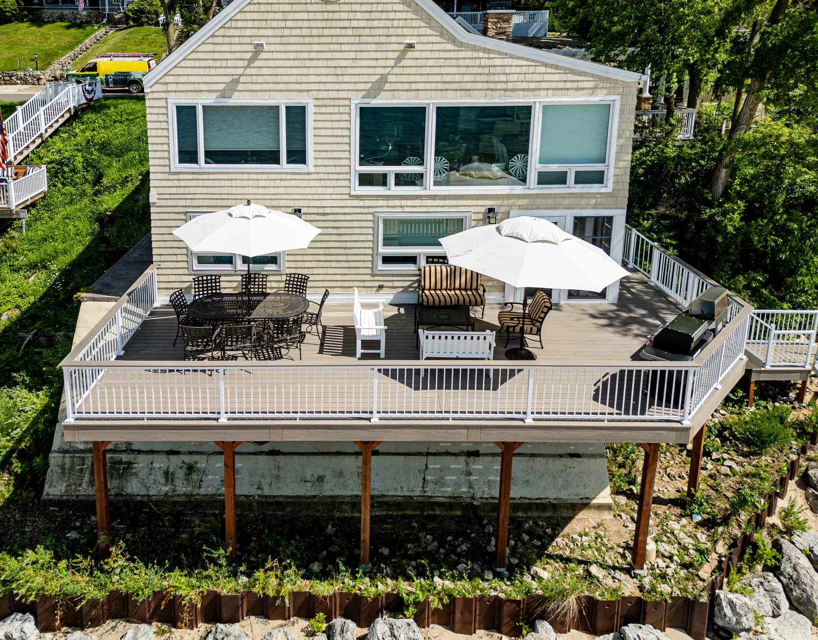 Elevated deck with white aluminum railing and umbrellas