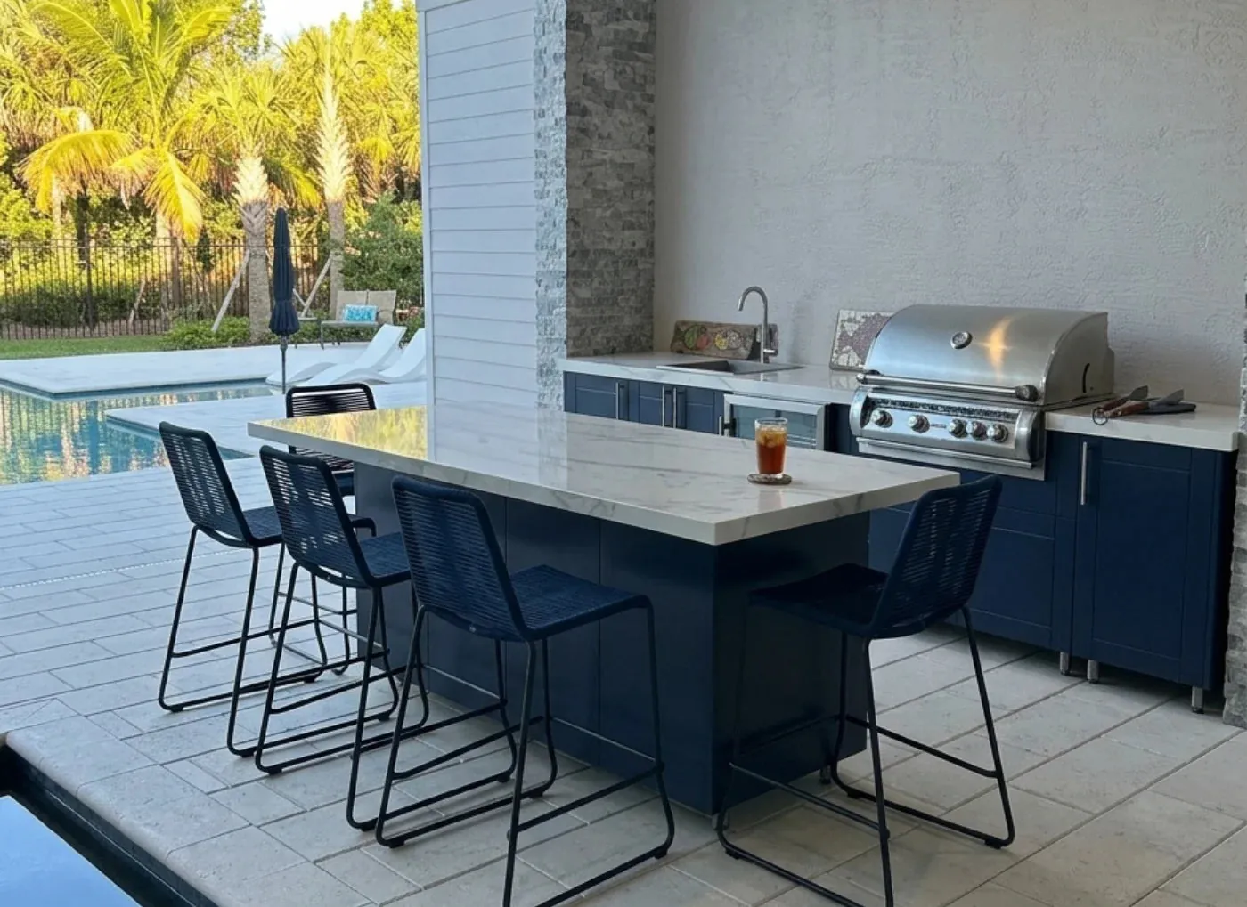 Navy outdoor kitchen bar beside a pool