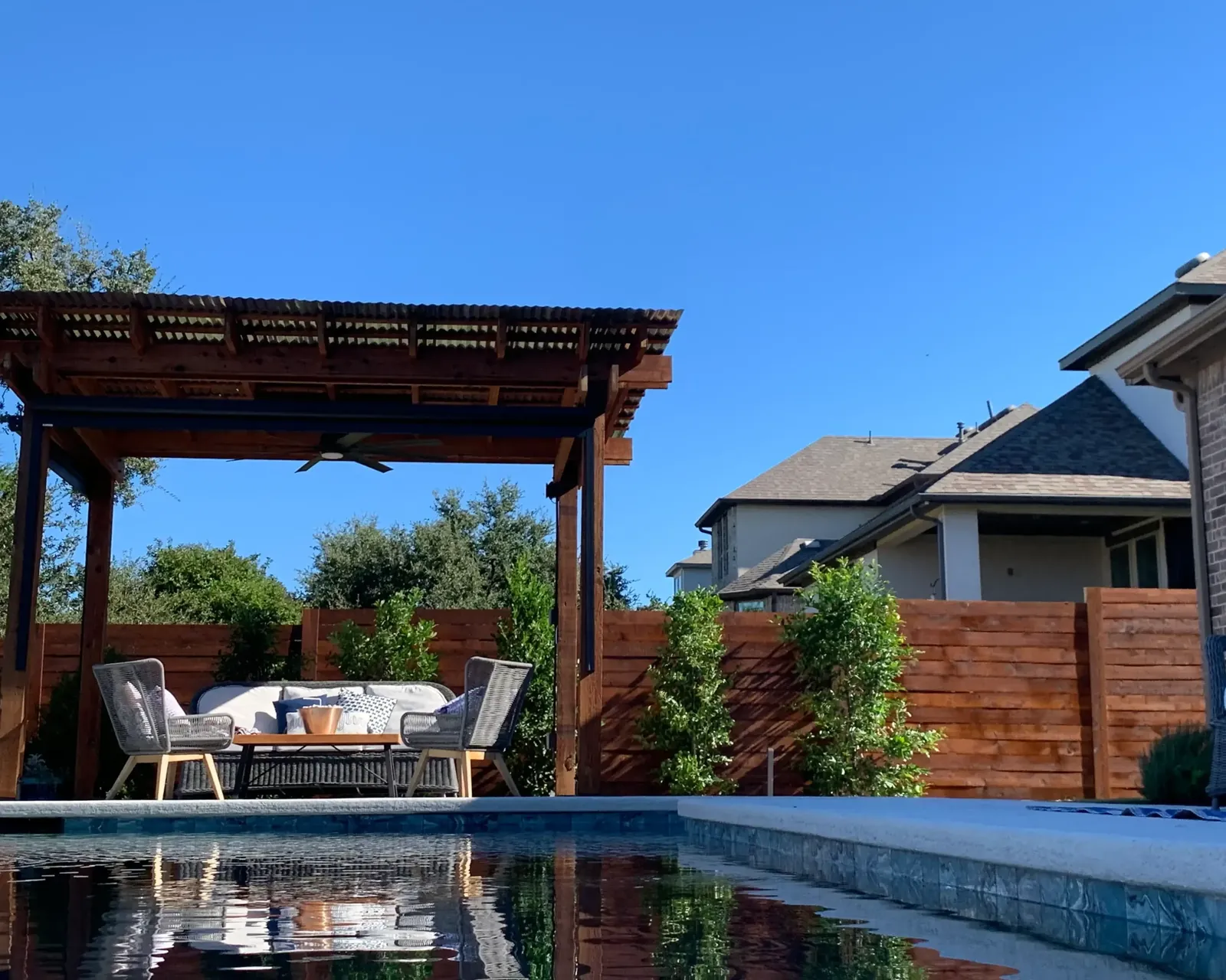 Cedar privacy fence and pergola around a pool