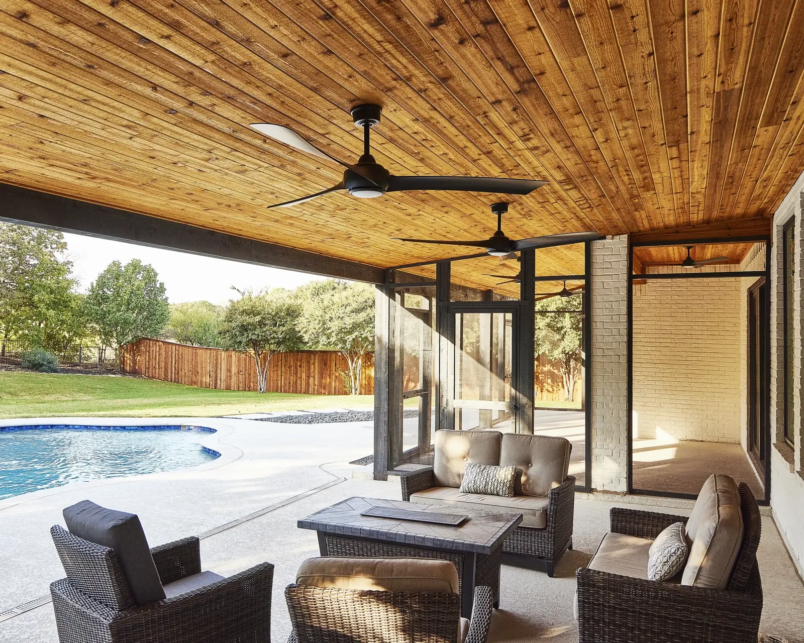 Covered patio with a stained wood ceiling by the pool