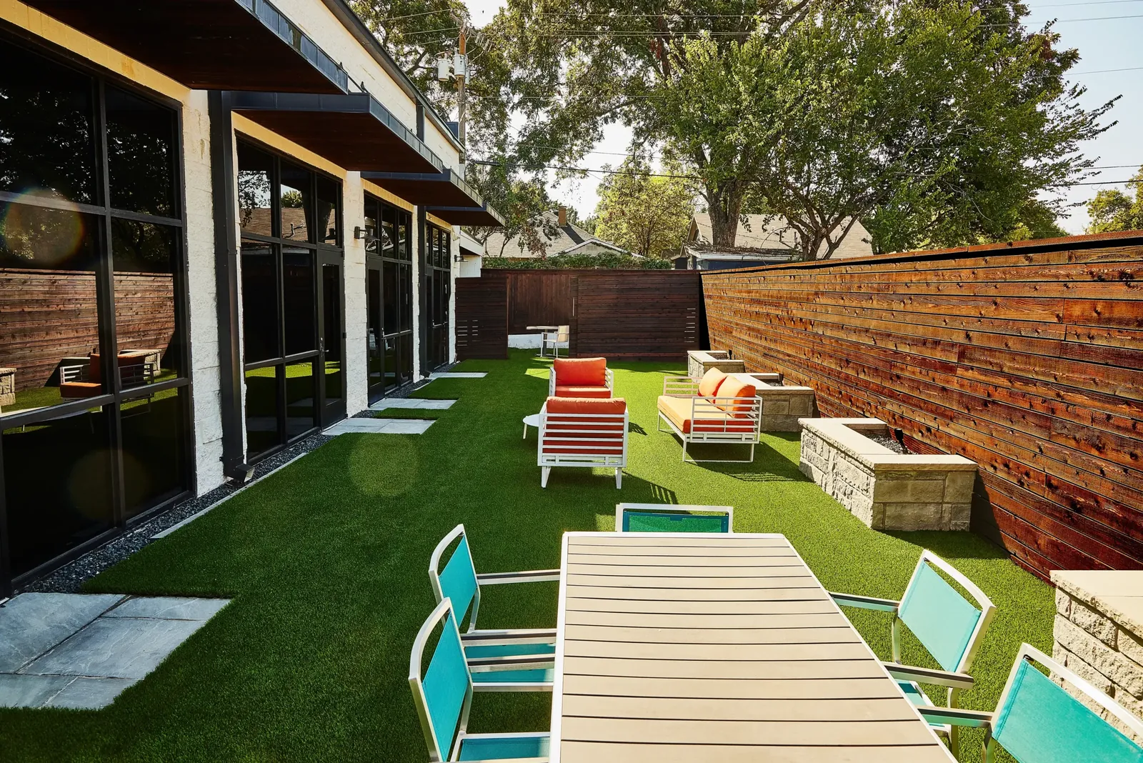 Horizontal stained fence around a turf courtyard