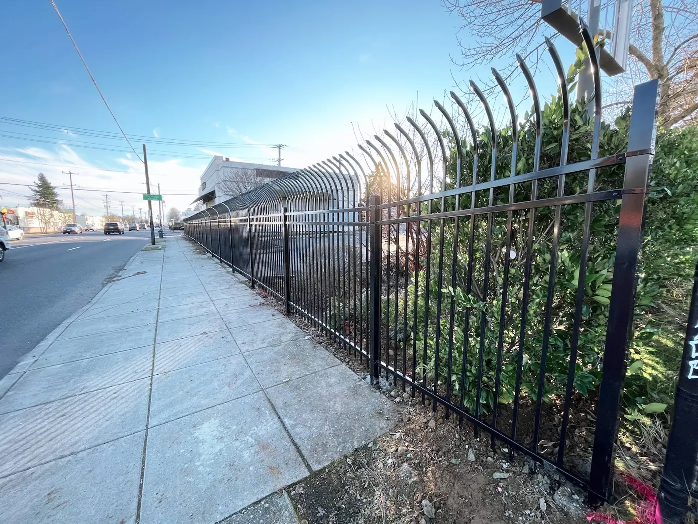 Highland steel fence with curved pickets along a sidewalk