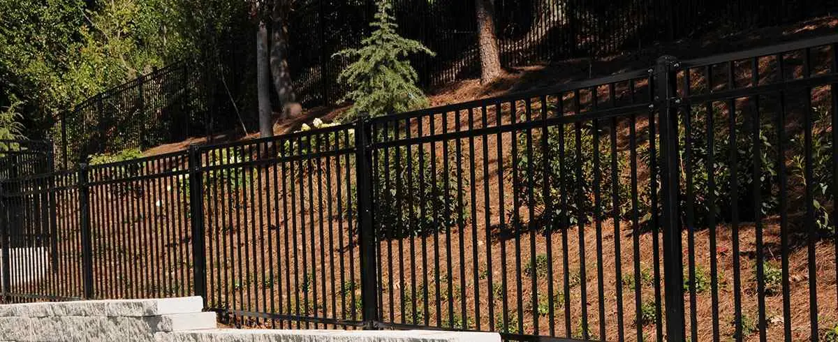 Highland black steel fence along a landscaped slope