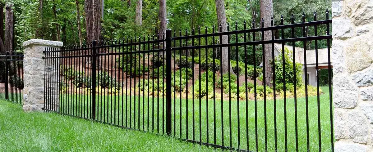 Highland black steel fence with stone pillar and lawn