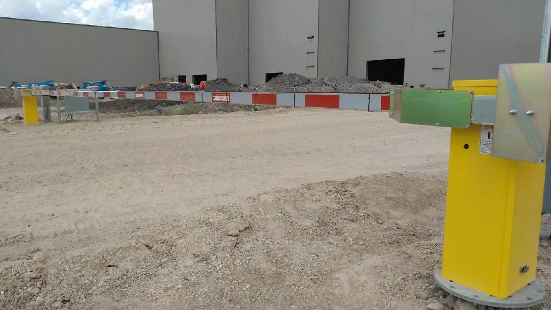 Barrier arm gate operator with striped arm at a vehicle entrance