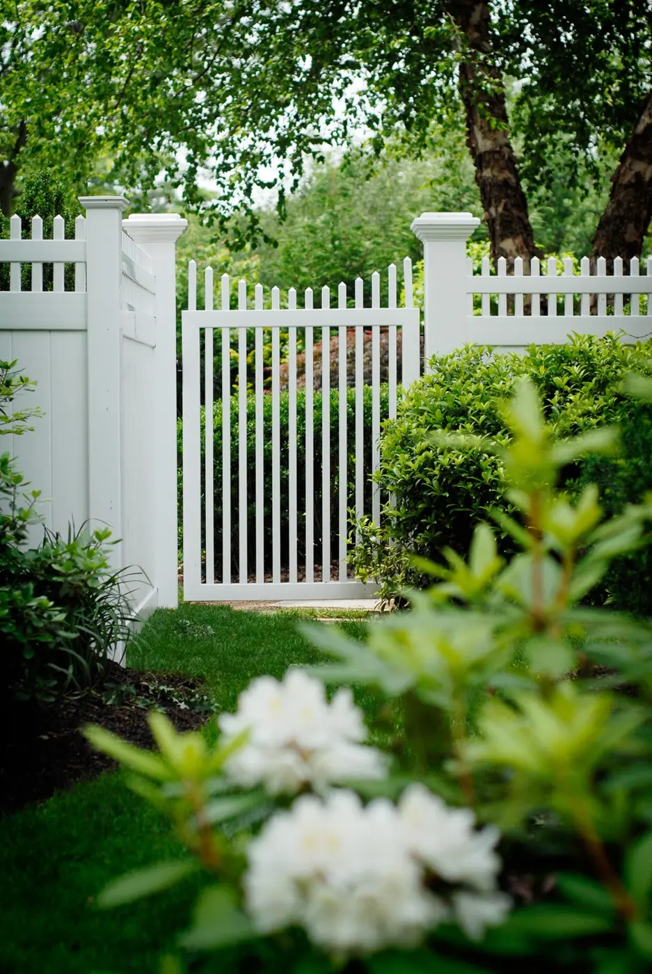 Illusions vinyl picket walk gate beside shrubs