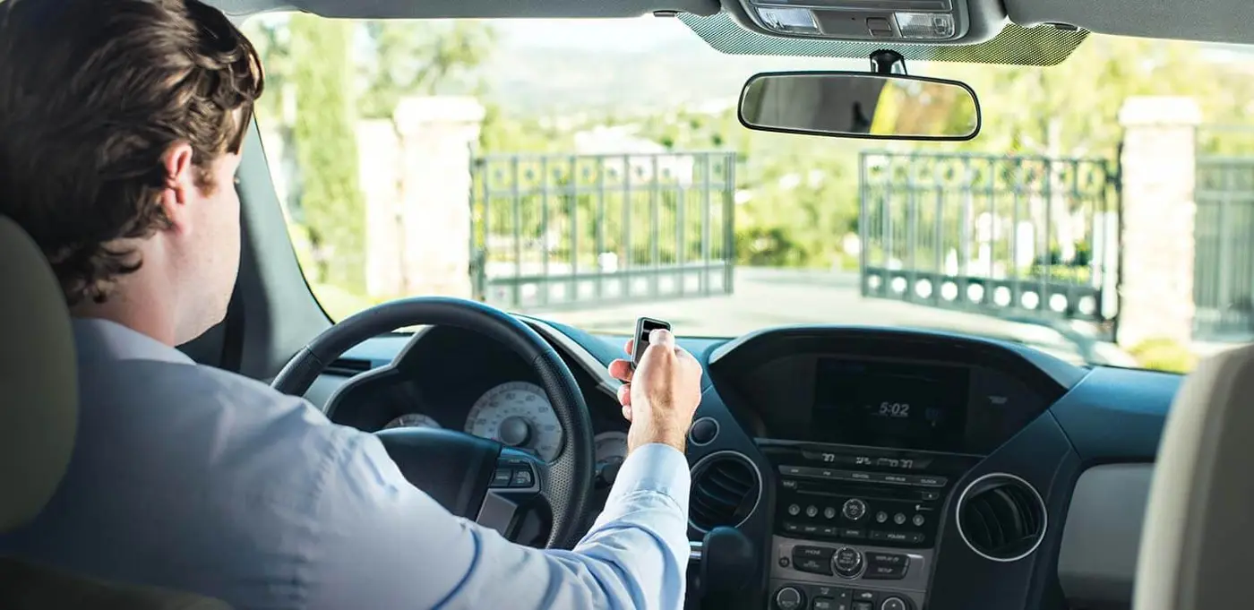 Driver using a LiftMaster remote at a gate