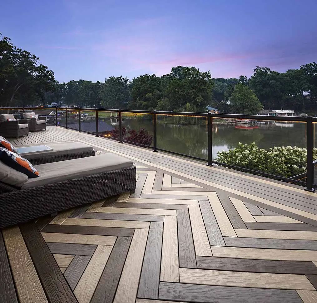 MoistureShield composite deck with glass and black metal railing at dusk