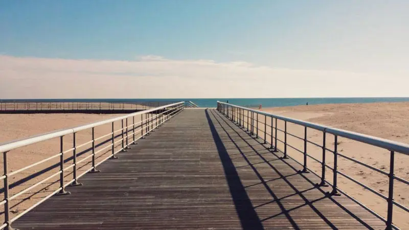 MoistureShield composite boardwalk with metal railings along the beach