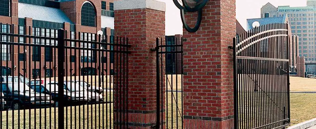 Monumental Iron Works ornamental gates between brick pillars