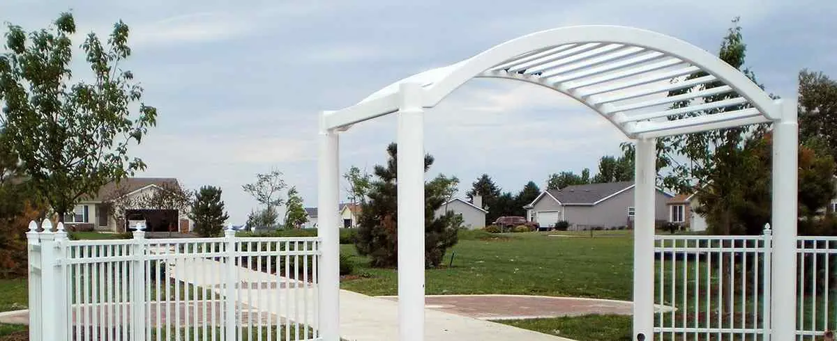 White ornamental fence with arbor entry