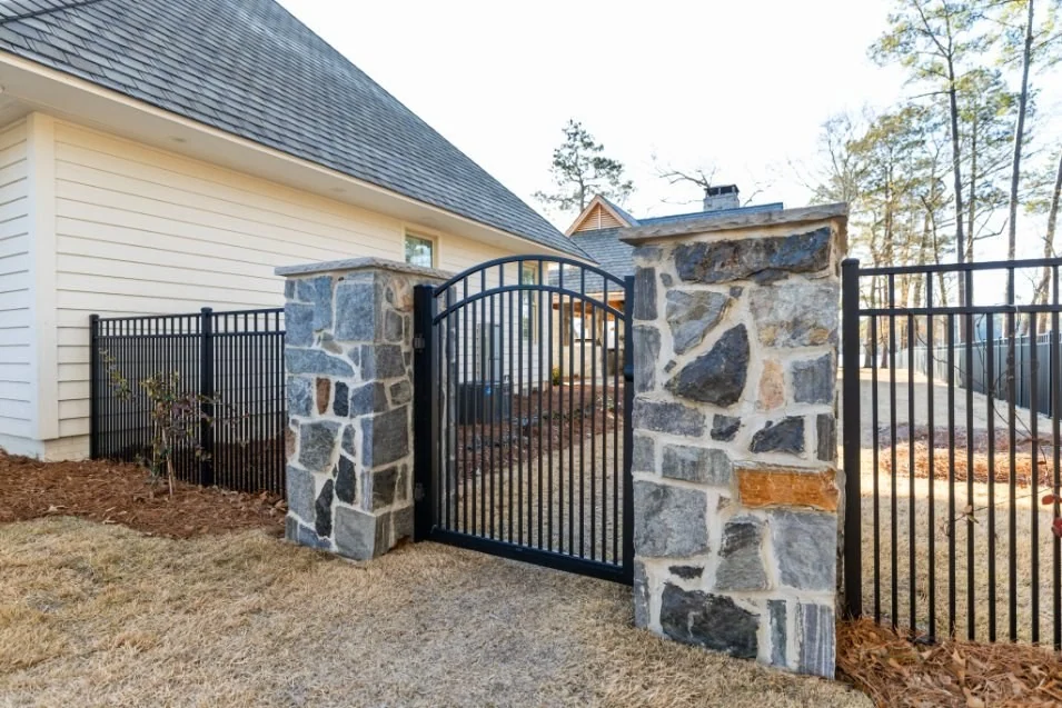 Custom aluminum gate between stone columns