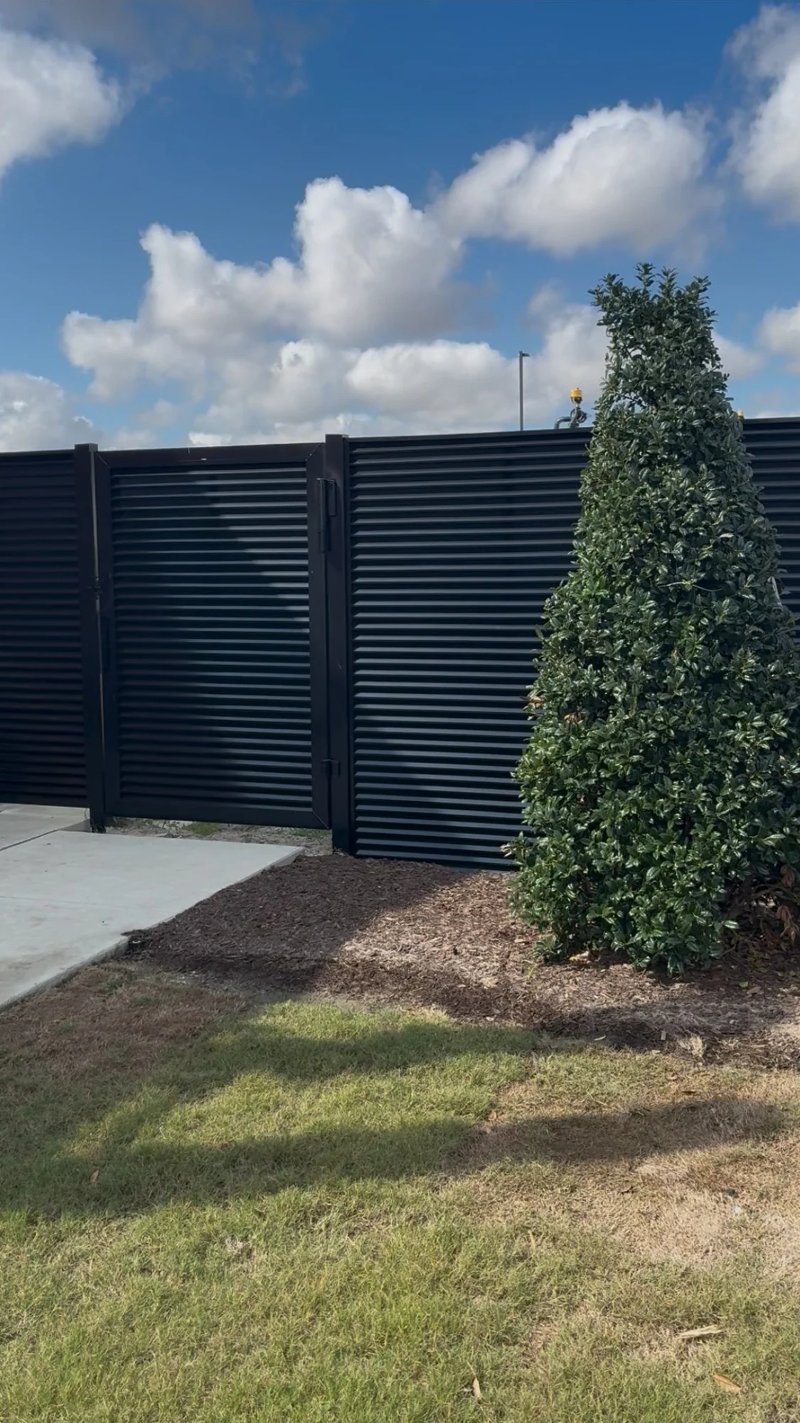 AirVeil louver fence enclosing a lawn edge