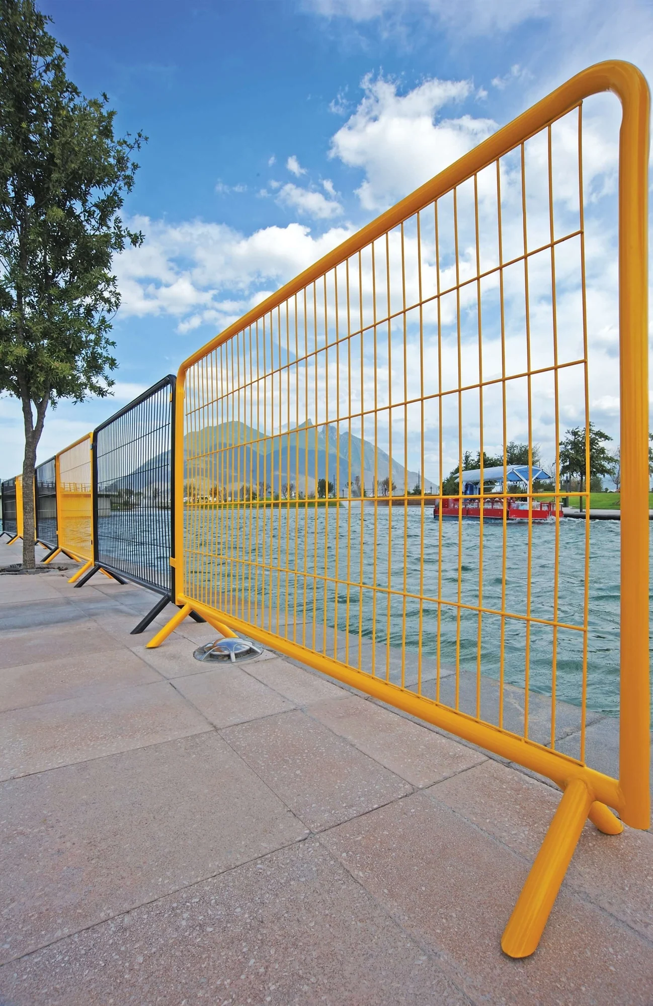 Yellow Designmaster Crowd Control barrier on a paved plaza
