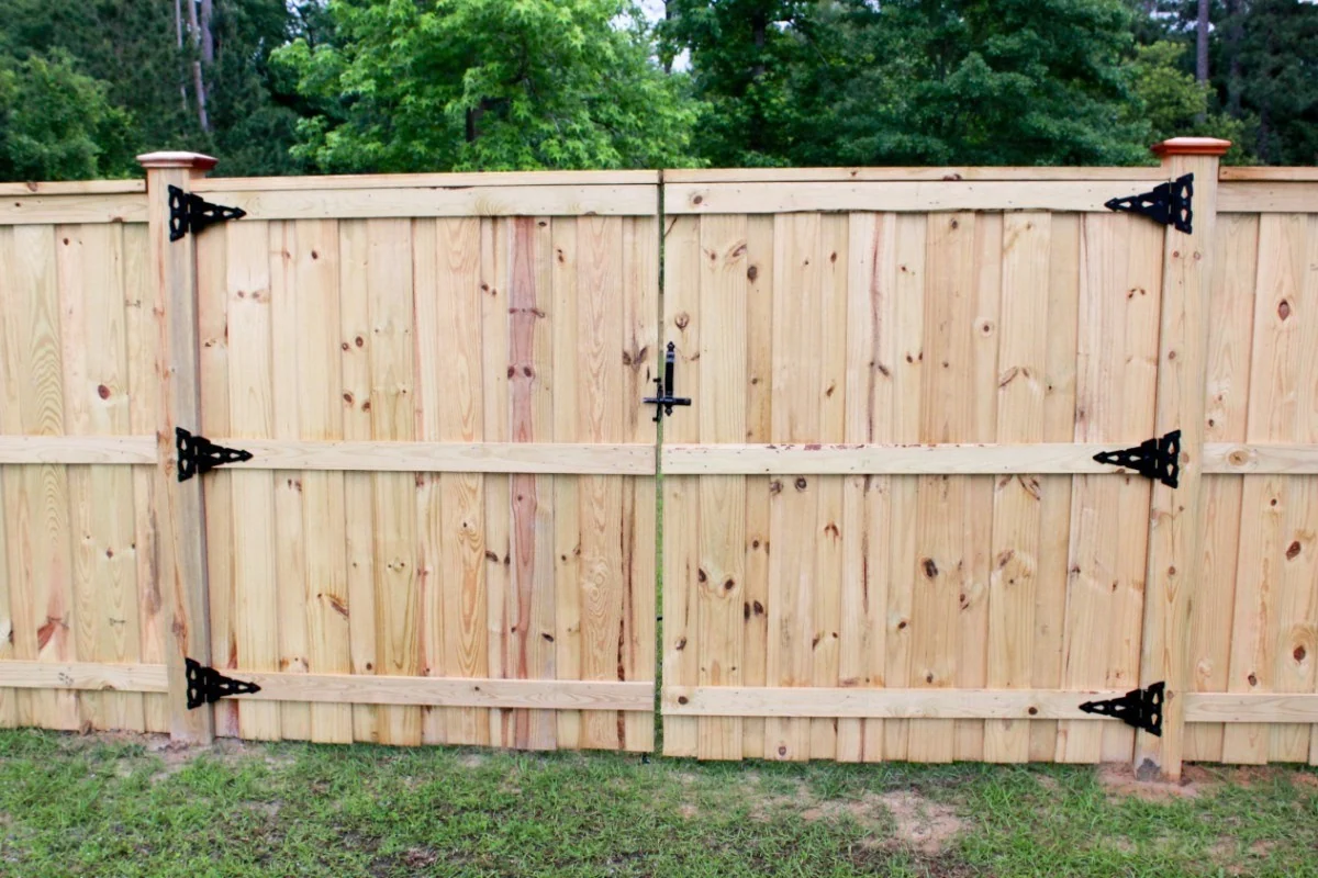 Wood board-on-board gate with black hinges