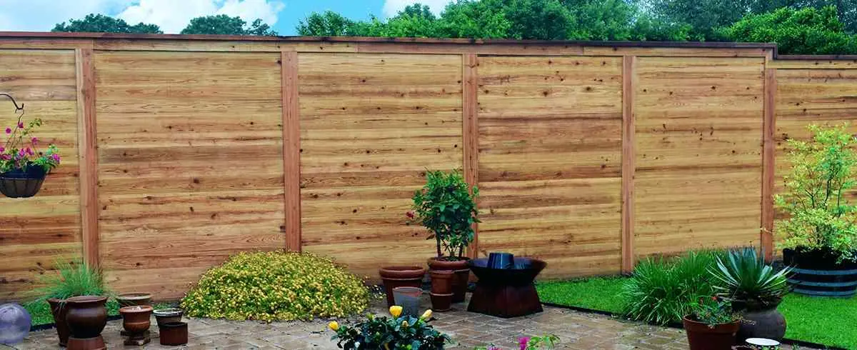 Horizontal cedar privacy fence on PostMaster+ posts in a garden