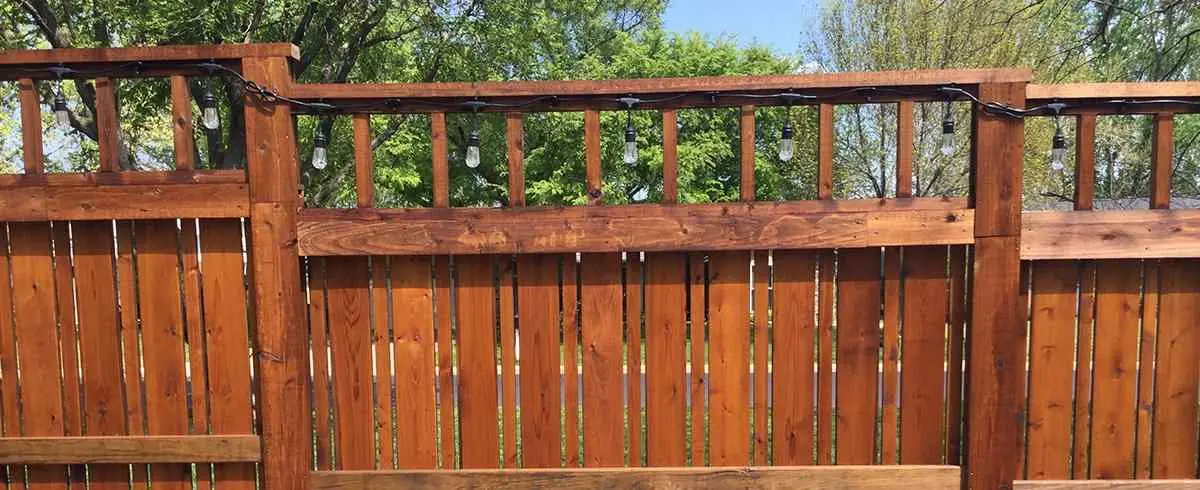 Stained wood privacy fence with lattice top on PostMaster posts