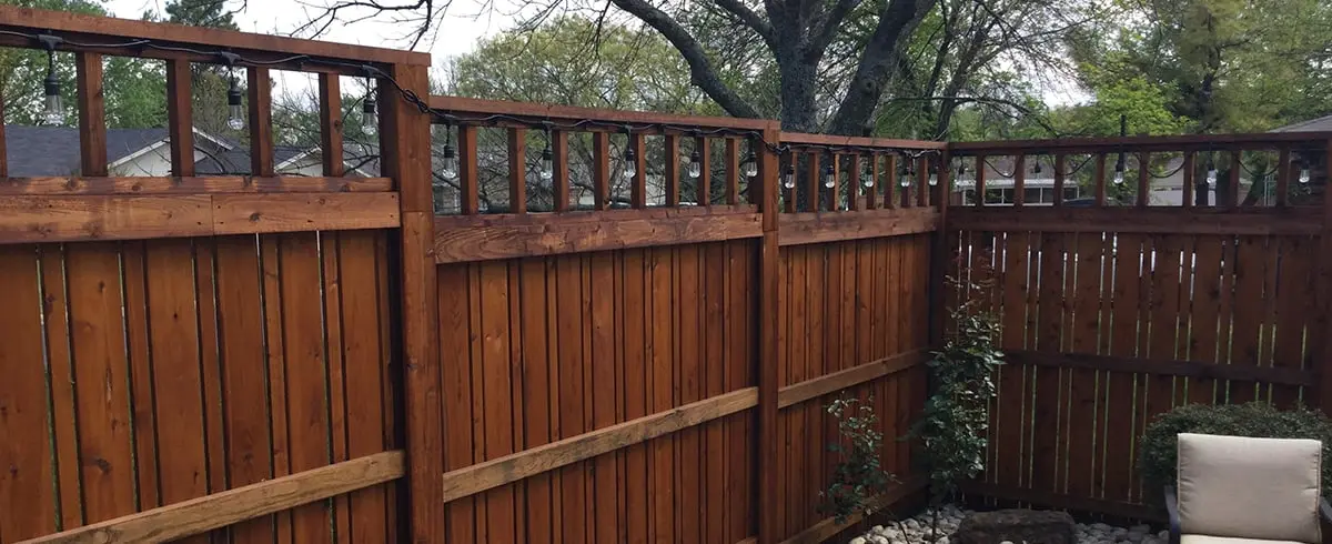 Stained wood privacy fence corner on PostMaster posts