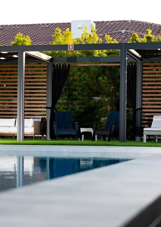 StruXure Cabana X MOD cabana with wood slat background beside a pool