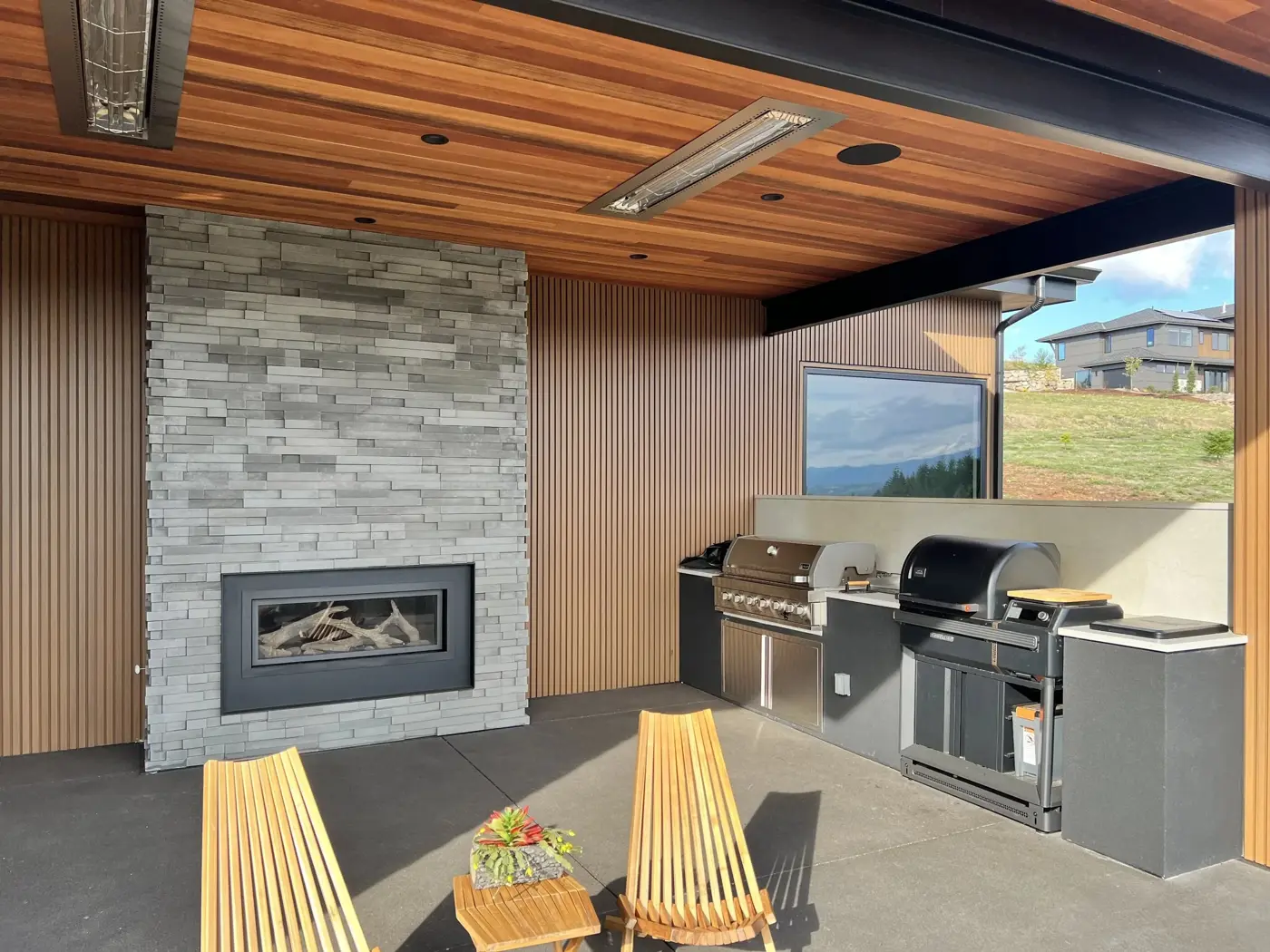 Covered patio with grill station and stone fireplace