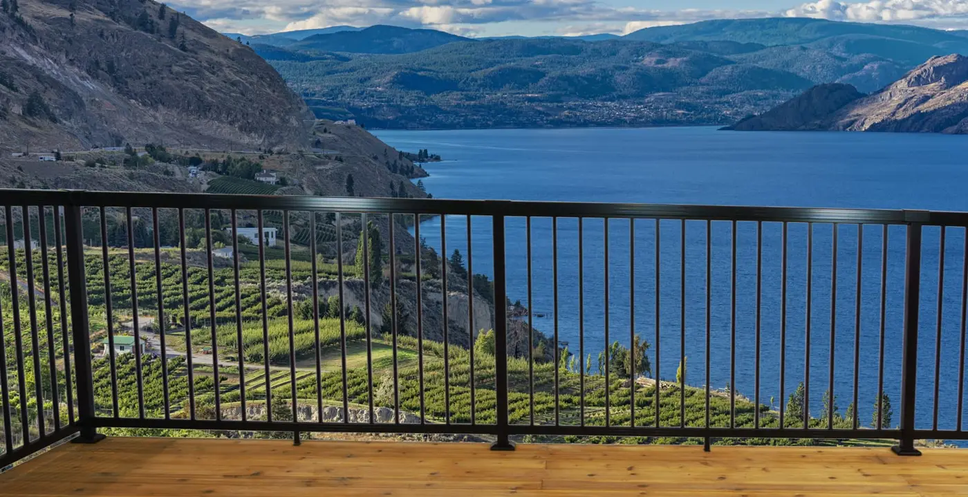 Black aluminum railing on a deck overlooking a mountain lake