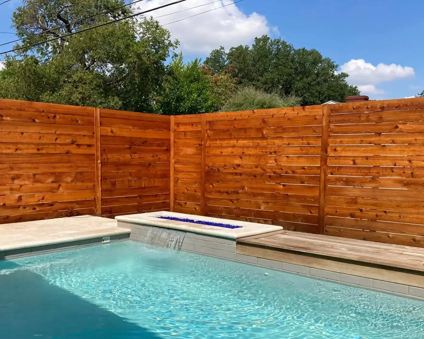 Horizontal cedar fence surrounding a backyard pool