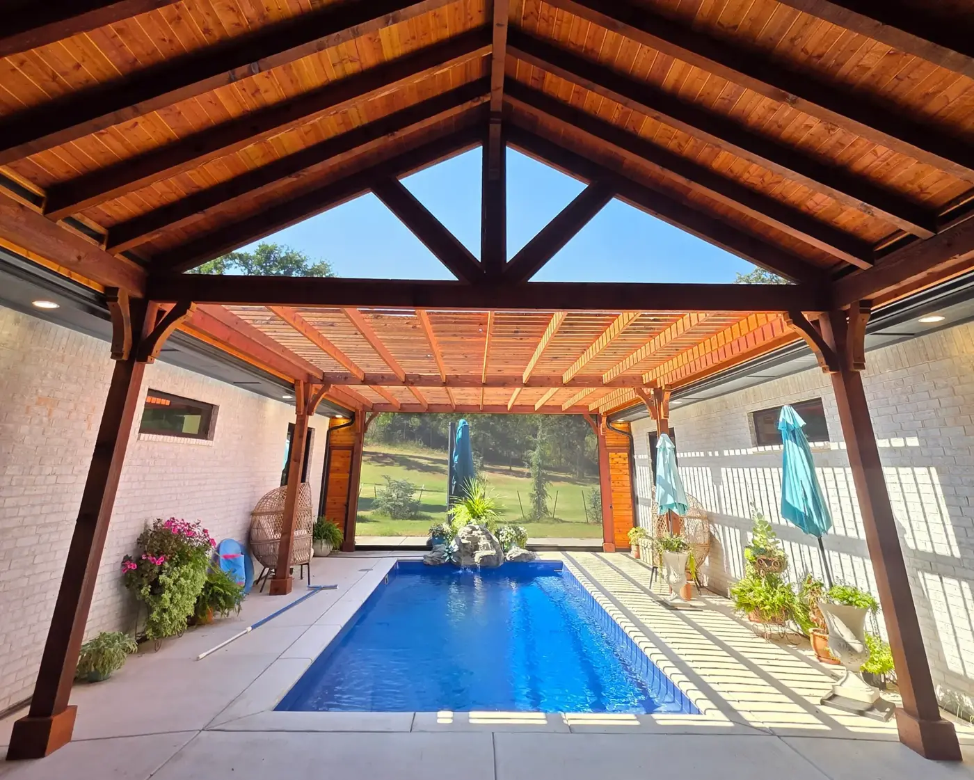 Open timber pavilion overlooking a backyard pool